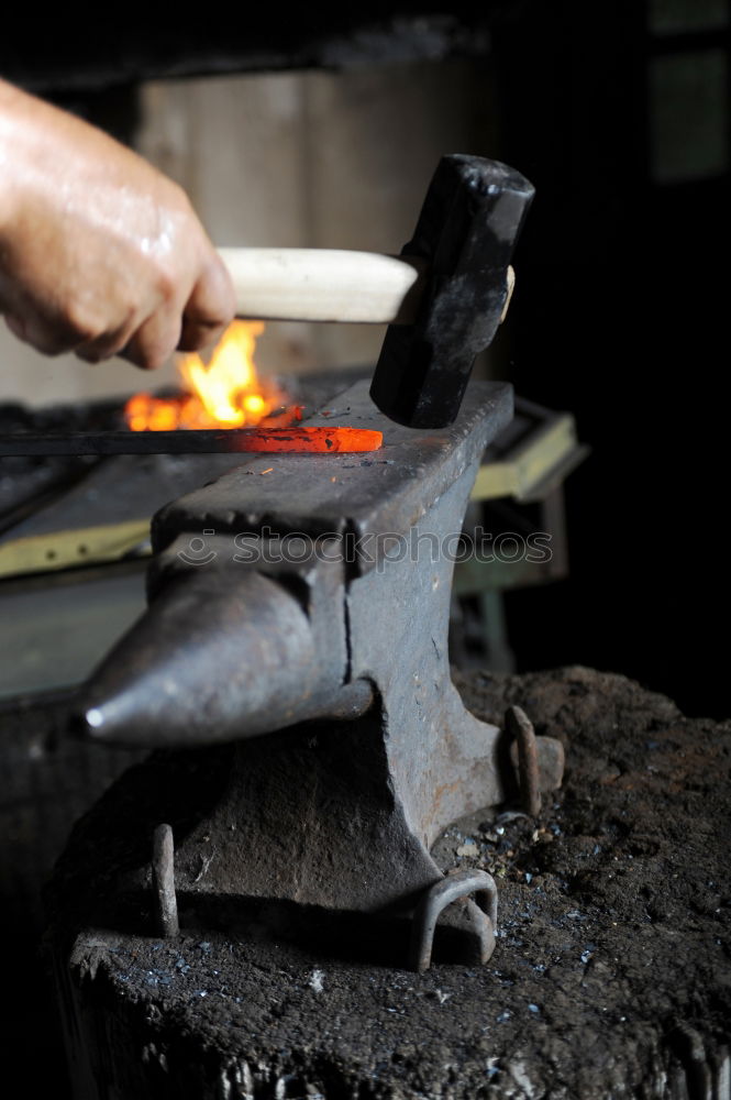 Similar – Blacksmith forges iron on anvil