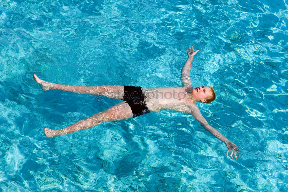 Similar – Woman swimming underwater in blue sea