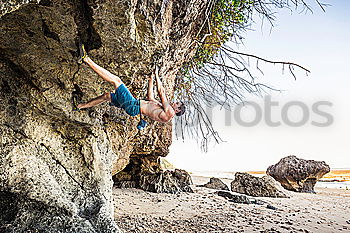 Young rock climber woman climbing the rock wall