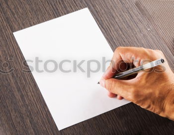 A woman’s hand holding an empty notebook