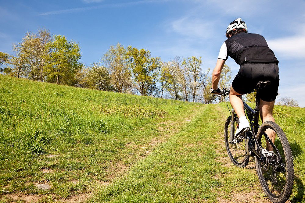 Mountainbikeradfahrer, der aufwärts entlang einer Landstraße reitet