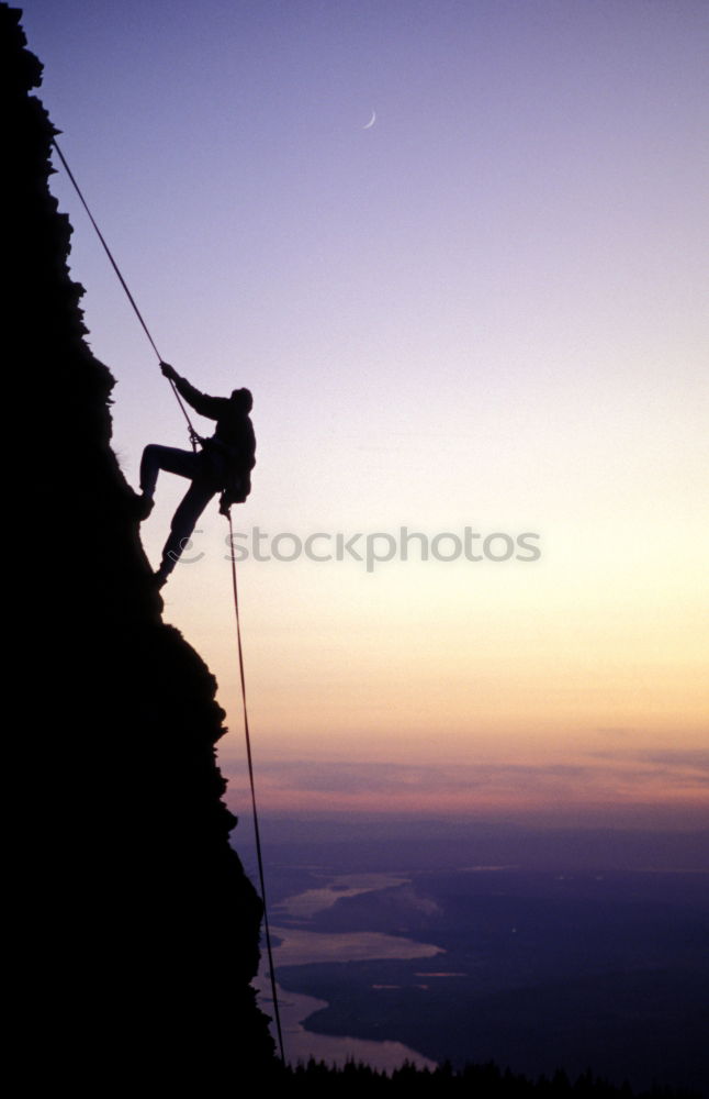 Similar – Rock climber clinging to a cliff.