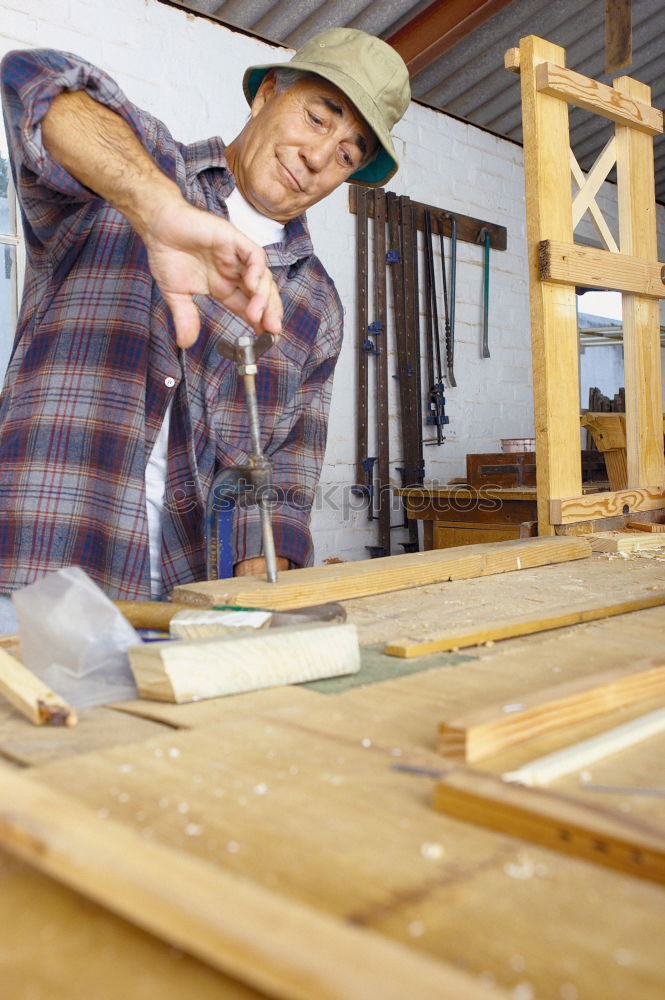 Similar – Professional carpenter cutting wooden board at his workshop