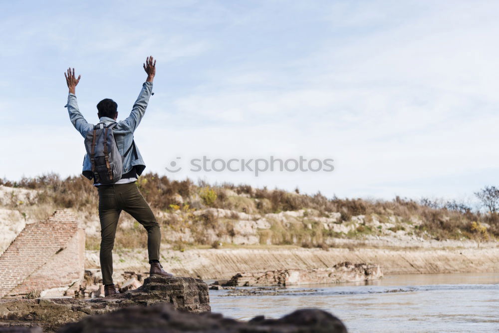 Similar – Man with tattoos holding skateboard at shore. Back view.