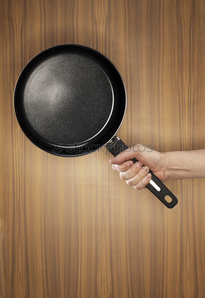 Similar – cook in red uniform holding an empty black frying pan