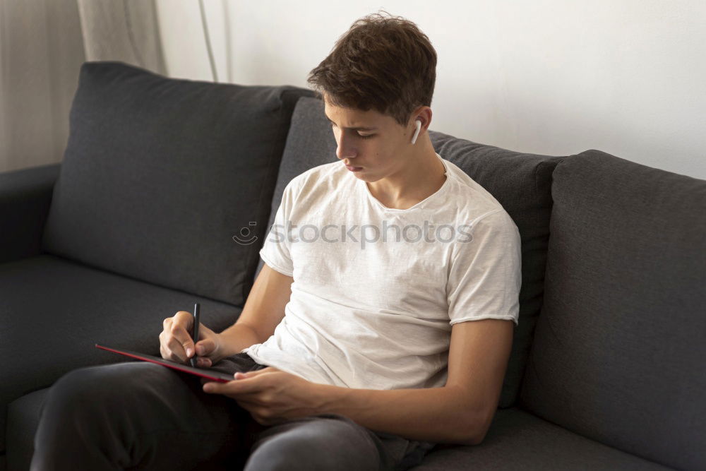 Similar – Portrait of relaxed young boy sitting at the patio door and listening to music from mobile phone