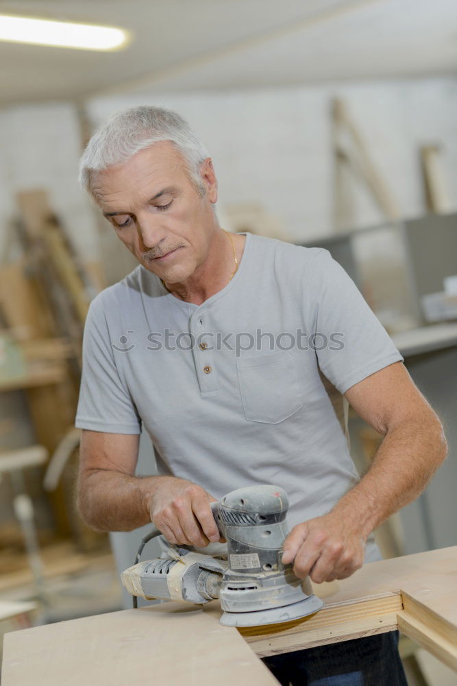 Similar – Carpenter cutting wooden board