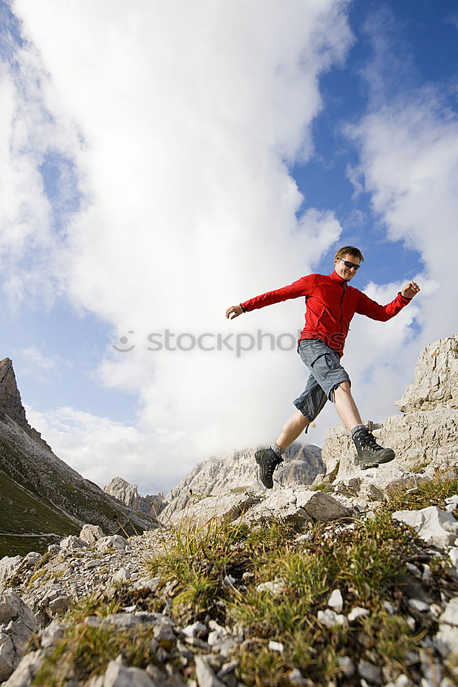 Similar – Woman walking in the mountains with sticks in her hands