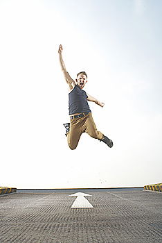 Similar – Woman jumping barefoot over blue rubber hills