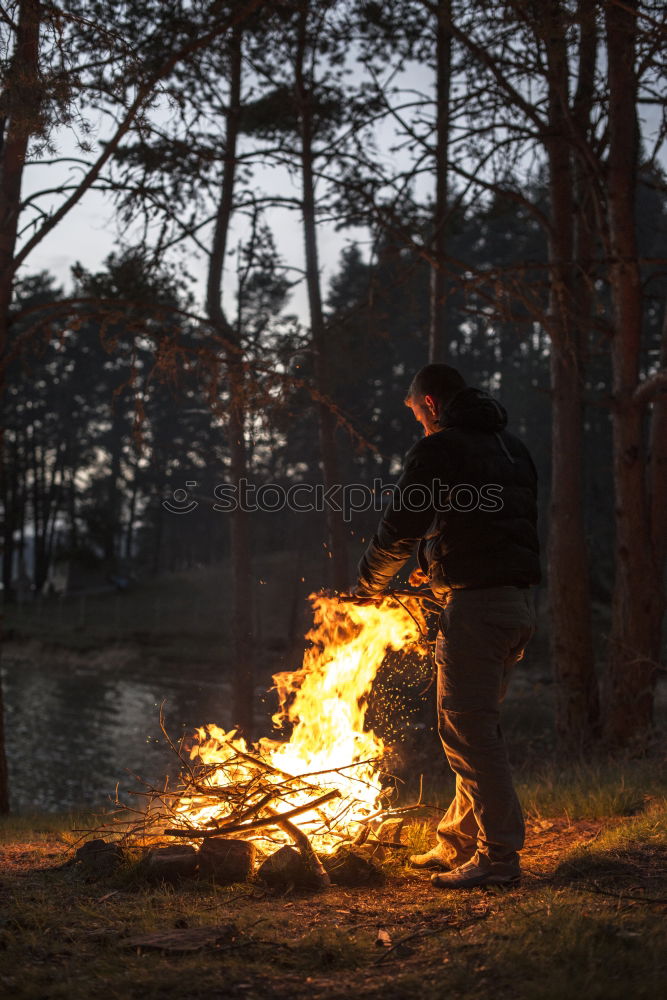 Similar – Man lights a fire in the fireplace in nature at night