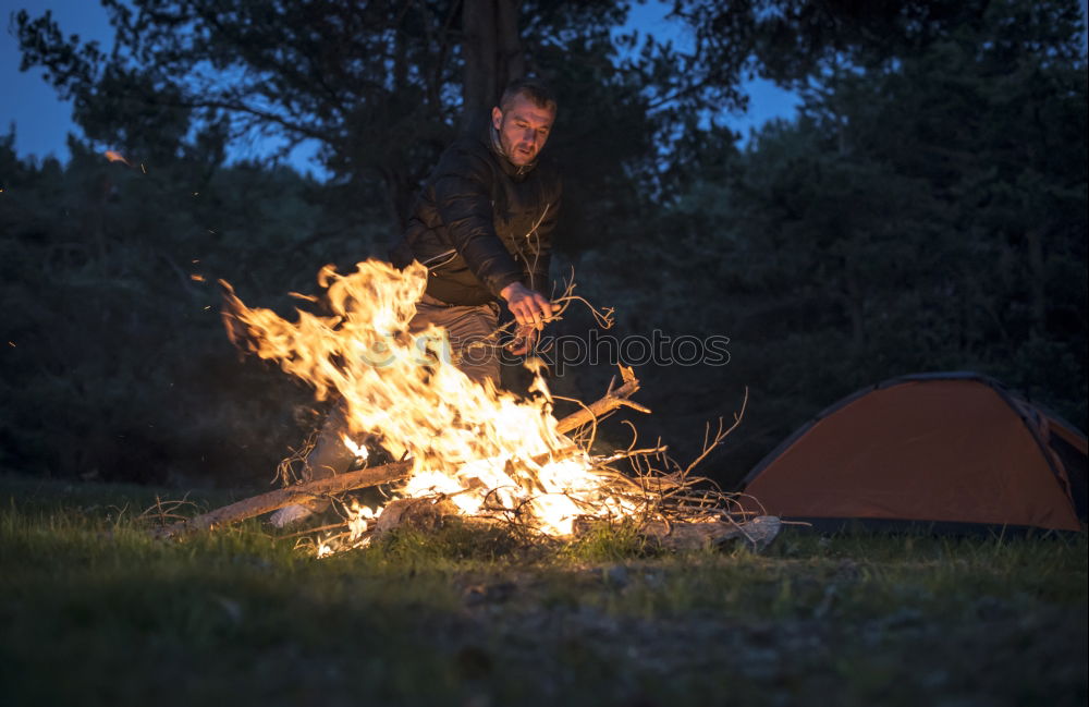 Similar – Man lights a fire in the fireplace in nature at night