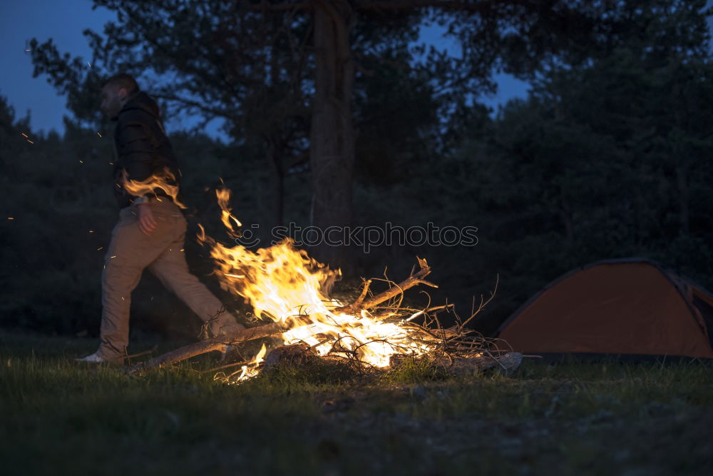 Man lights a fire in the fireplace in nature at night