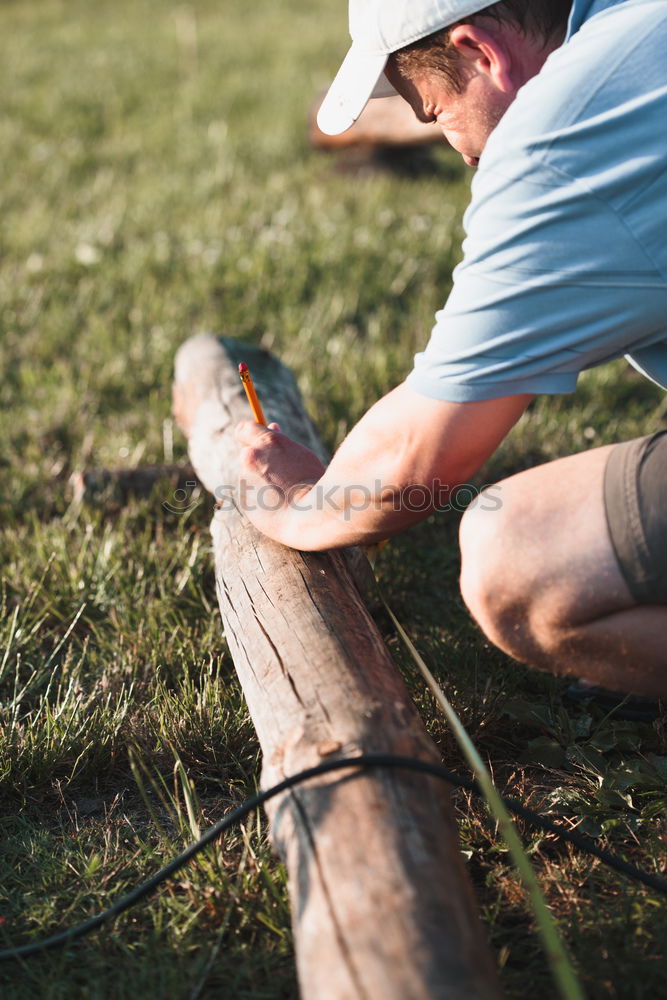 Man making mark by using pencil in garden