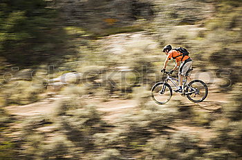 Similar – Downhill-Fahrer springt mit dem Fahrrad bergab und macht einen Peitschentrick