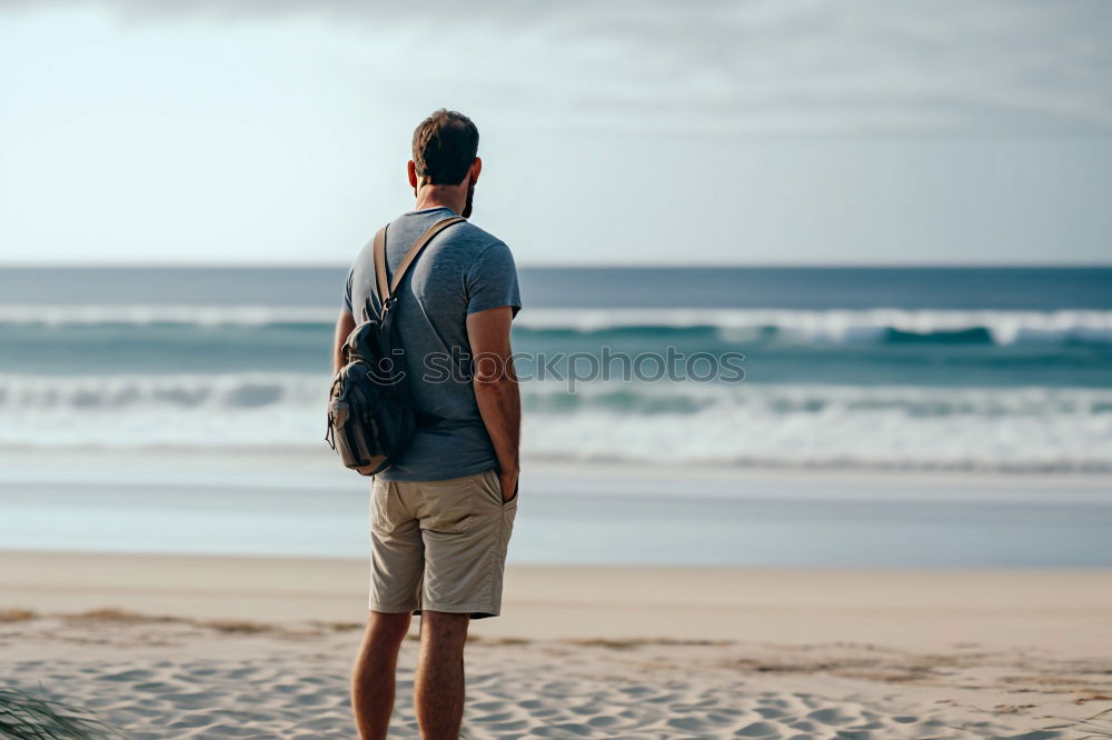 Similar – Man standing with skateboard at shore