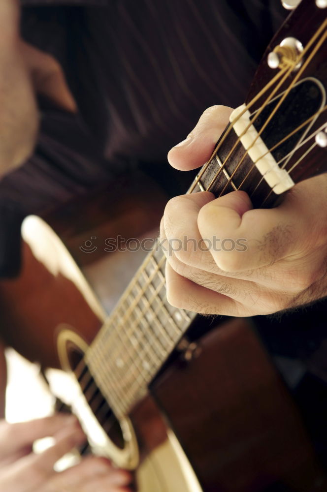 Similar – man playing spanish guitar and singing while recording it with a microphone