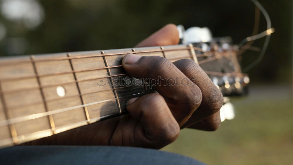 Similar – man playing spanish guitar and singing while recording it with a microphone