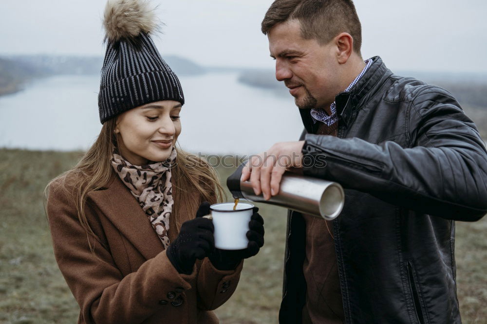 Similar – Young couple under blanket having hot drink in a cold day