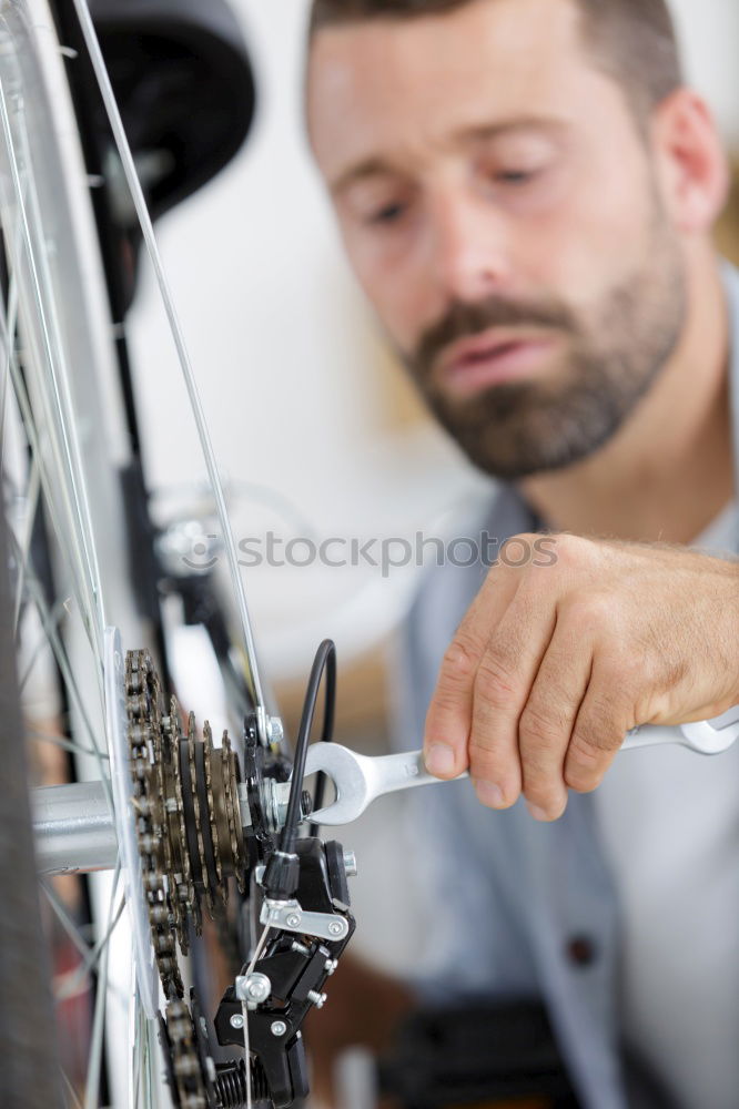 Similar – Man putting part on bike