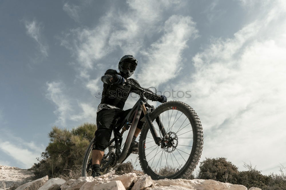 Similar – Downhill-Fahrer springt mit dem Fahrrad bergab und macht einen Peitschentrick