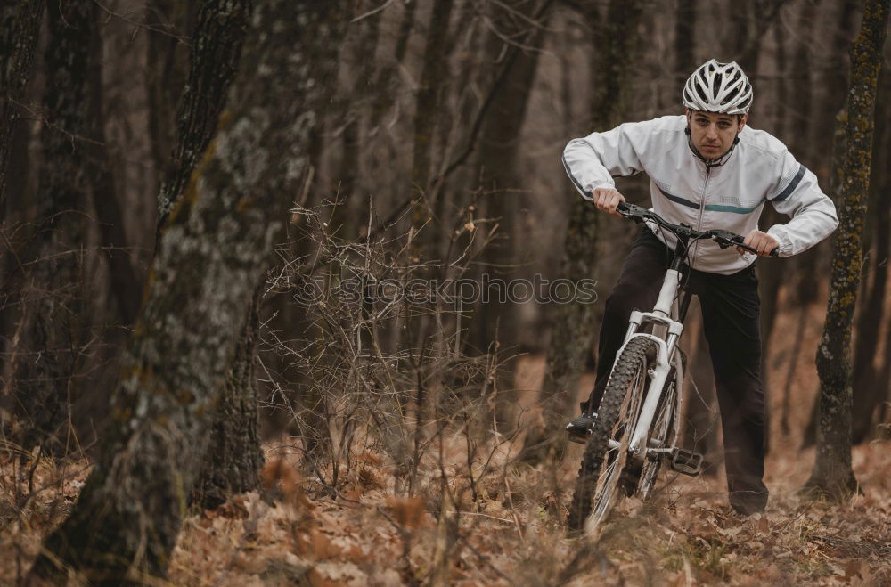 Similar – Biker in Jeans und kariertem Hemd springt mit dem Fahrrad die MTB-Strecke hinunter