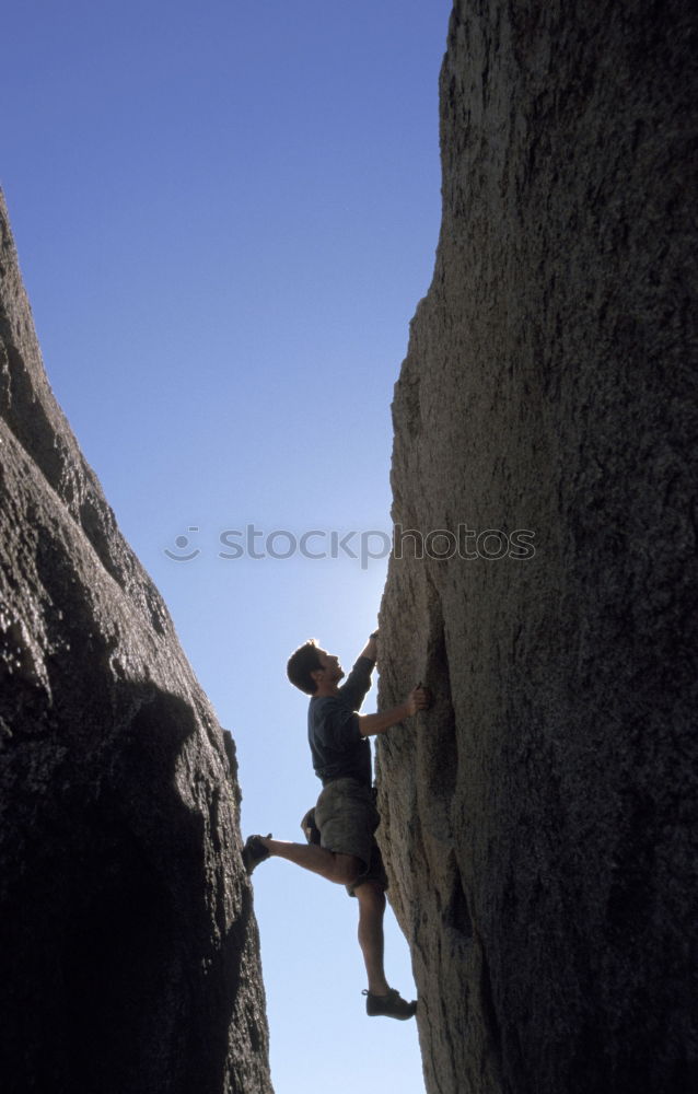 Similar – Rock climber clinging to a cliff.