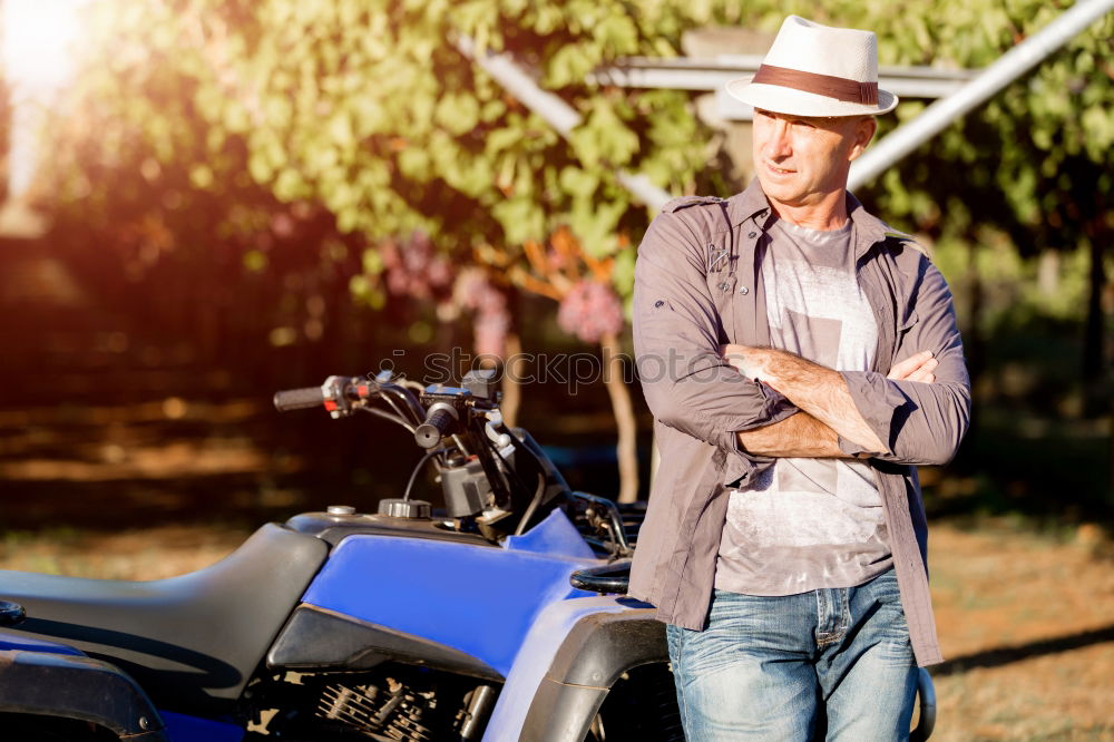 Similar – Long-haired brunette guy in sunglasses jeans and a jeans shirt posing on a black custom motorcycle