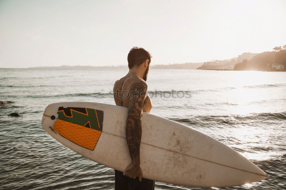 Tattooed man holding skateboard