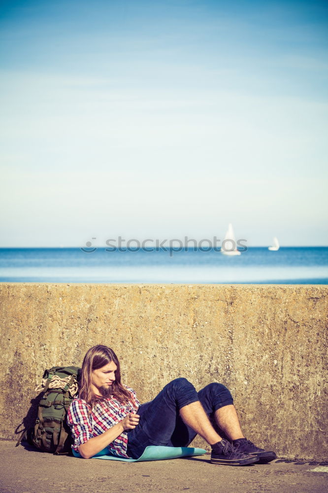 Similar – Image, Stock Photo Tourist sits on a bench on the beach