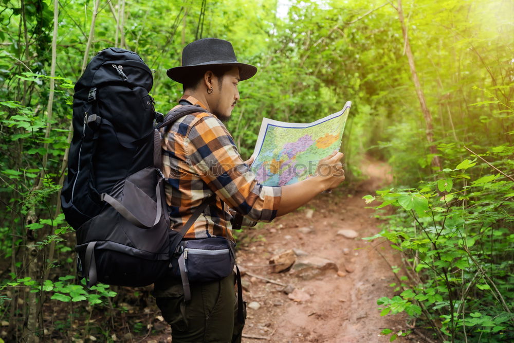 Similar – Man navigating on road in woods