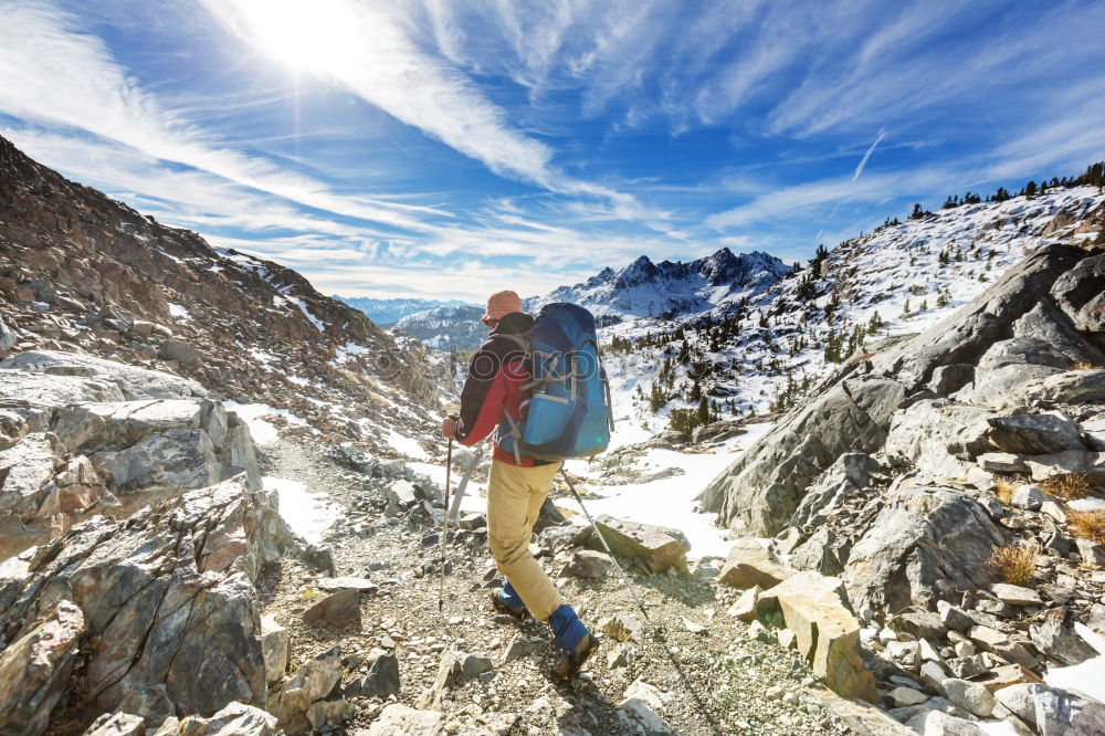 female hiker going up a mountain with snow.