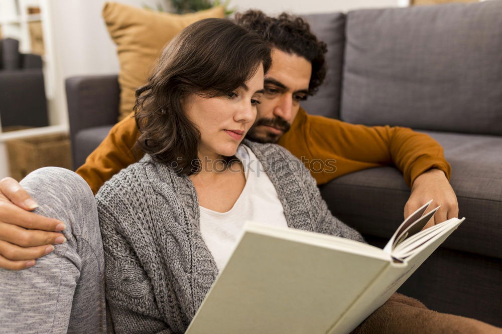 Similar – Image, Stock Photo Young couple reading book on couch at home