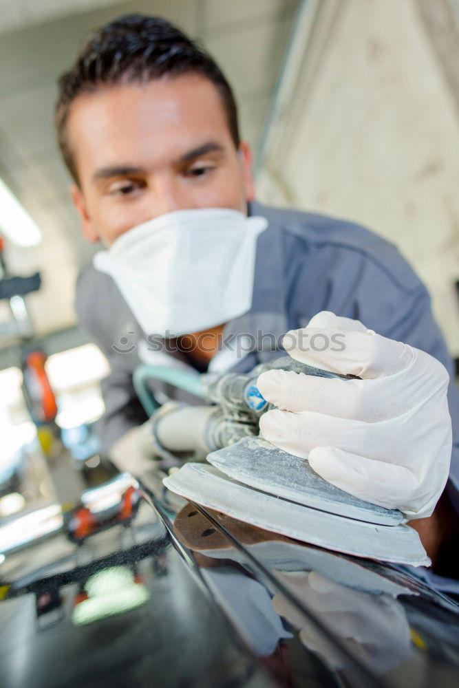 Similar – Man with a dust mask and goggles working on a circular saw