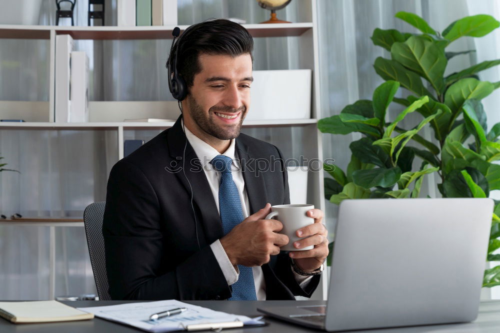 Similar – Image, Stock Photo Businessman enjoying coffee and checking his mobile phone for messages with a smile with his laptop and tablet open on the table