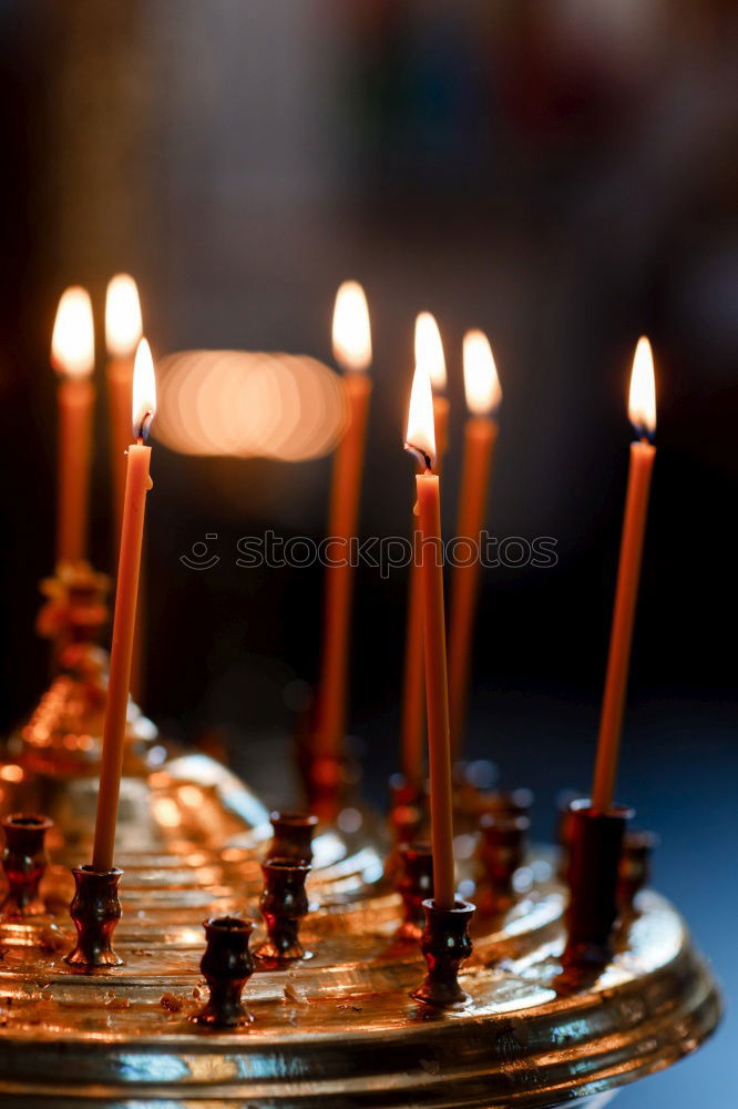 long lighted candles group in orthodox church. candles background. selective focus