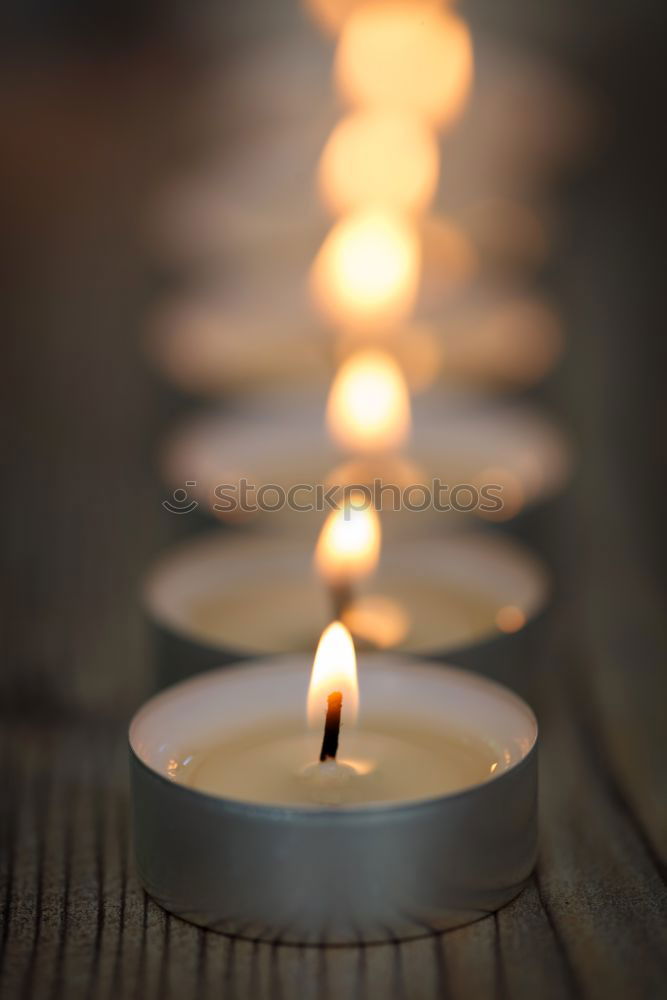 Advent arrangement with four candles. In the background the blurred lights of the Christmas tree.