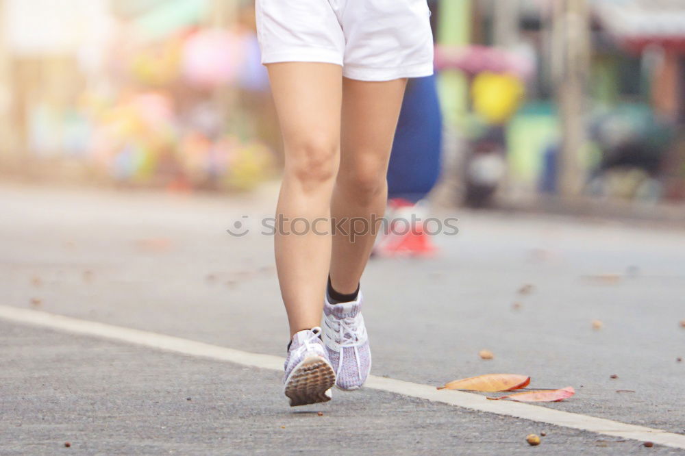 Young woman jogging down an autumn street