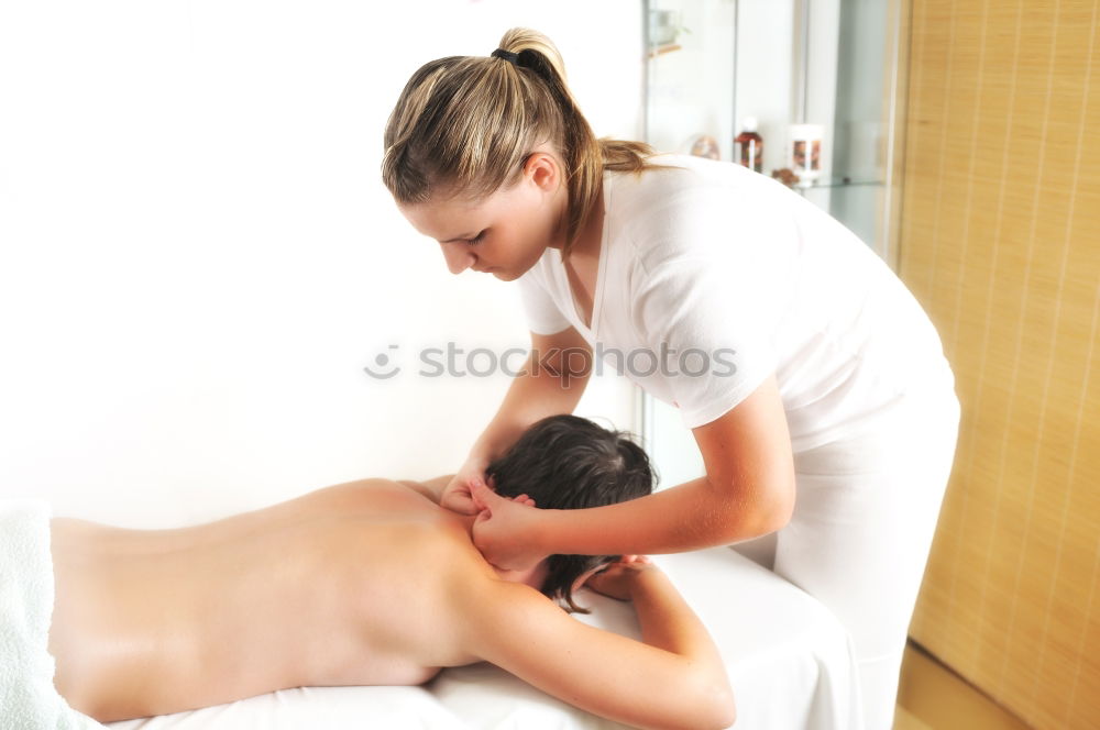 Similar – Woman at beauty spa getting a procedure with hot stones while massage therapist doing arm massage