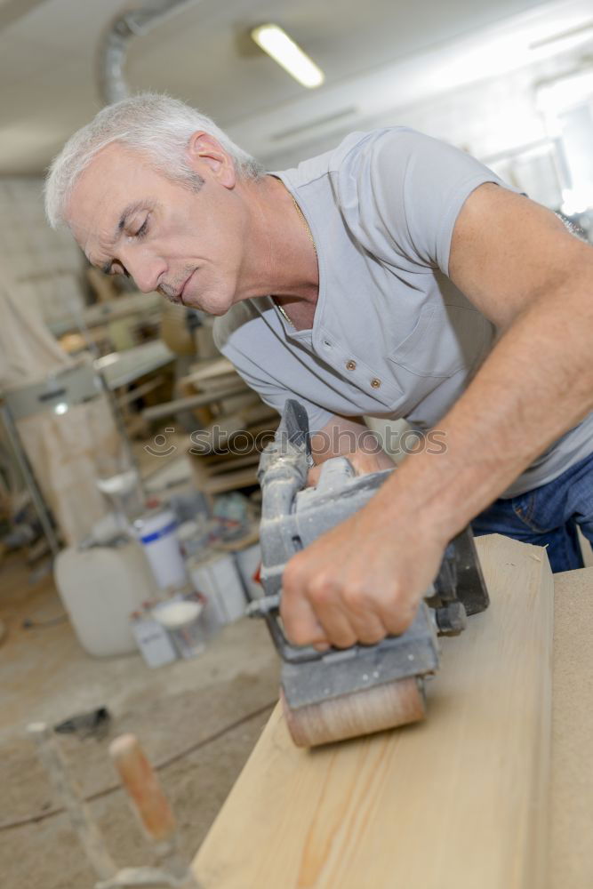 Similar – Image, Stock Photo Carpenter using belt sander. Carpenter sanding a wood