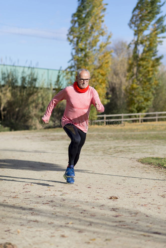 Similar – Senior runner man jumping arms up after running