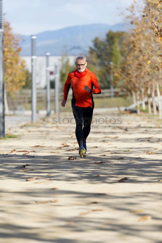 Similar – Senior runner man jumping arms up after running