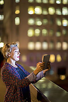 Similar – Image, Stock Photo Young people using tablet computer at home. They looking at pictures standing by the window in the evening. City lights outdoor