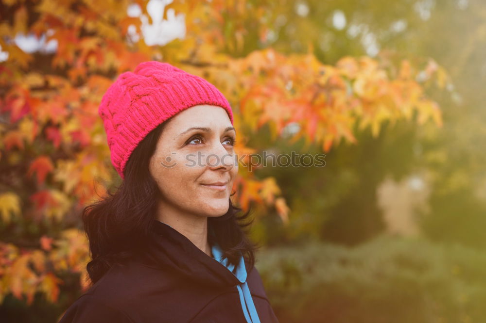 Matured woman with pink wool hat in the forest