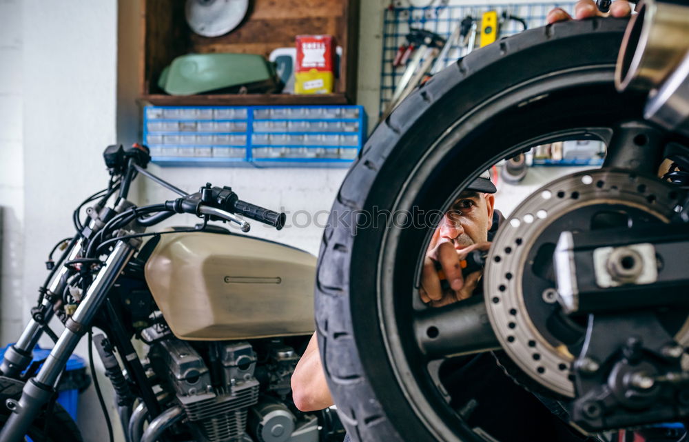 Image, Stock Photo Mechanic fixing custom motorcycle wheel
