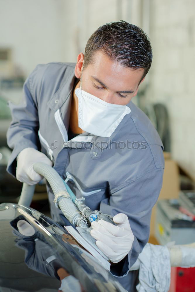 Man with a dust mask and goggles working on a circular saw