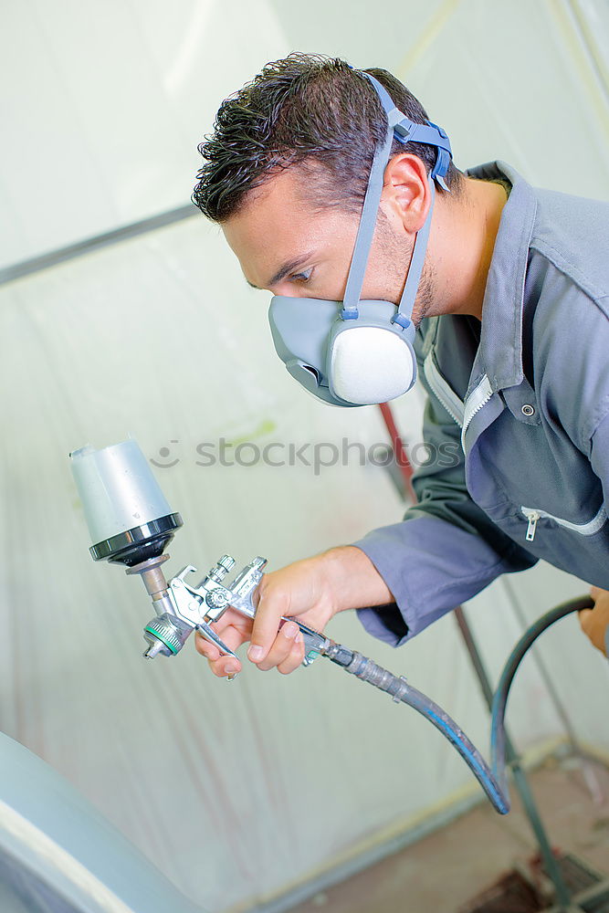 Similar – Man with a dust mask and goggles working on a circular saw