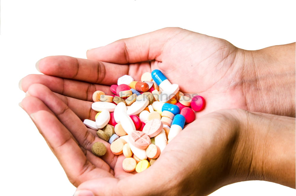 Similar – A hand in which several different colored tablets are lying; addiction problems, drug abuse, suicide