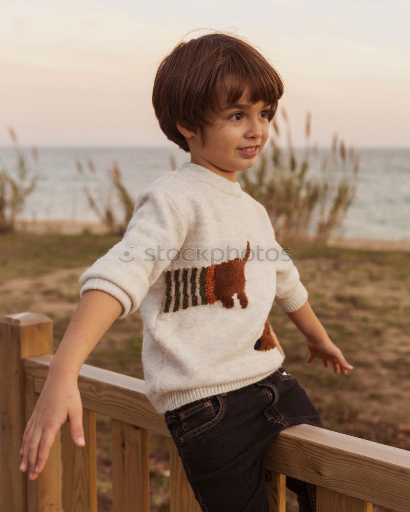 Similar – Little boy with a mibile phone with a wooden door background