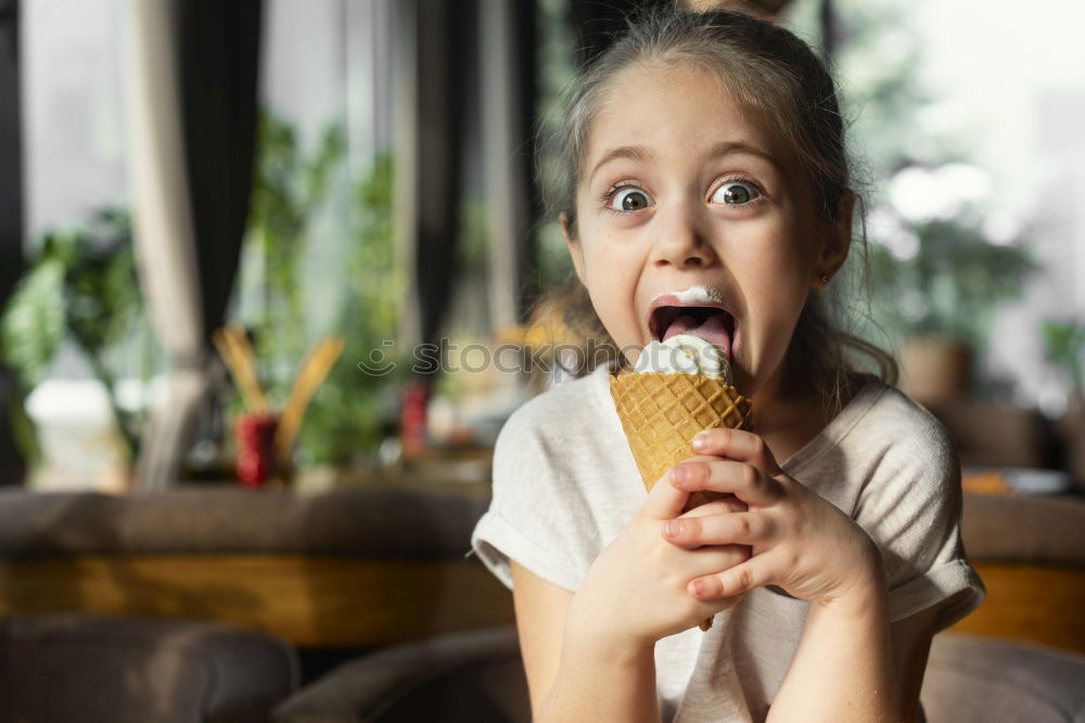 Similar – Little boy in a cafe during lunch. Hungry kid eating sausage from his sandwich