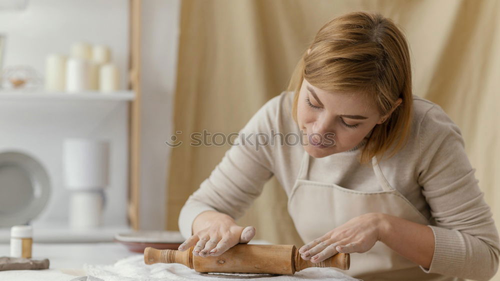 Similar – Image, Stock Photo Young female sitting by table and making clay or ceramic mug in her working studio